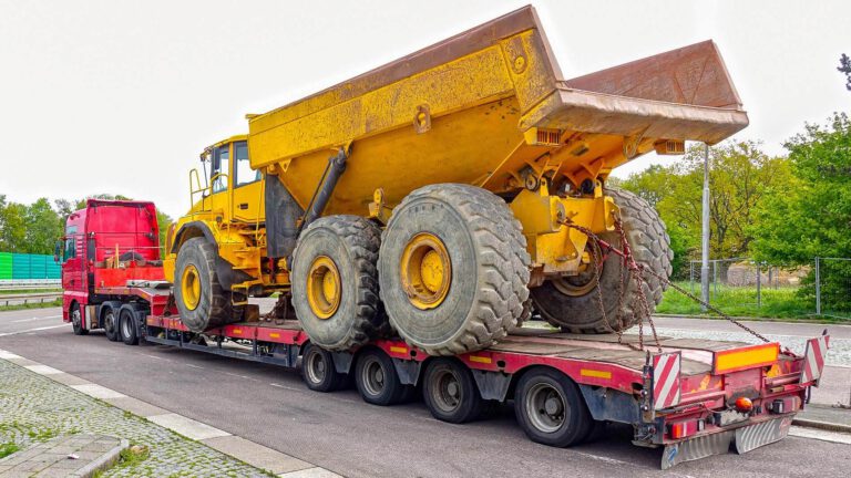 czerwony-samochod-laweta-do-transportu-niskopodwoziowego-ktora-przewozi-duza-zolta-wywrotke