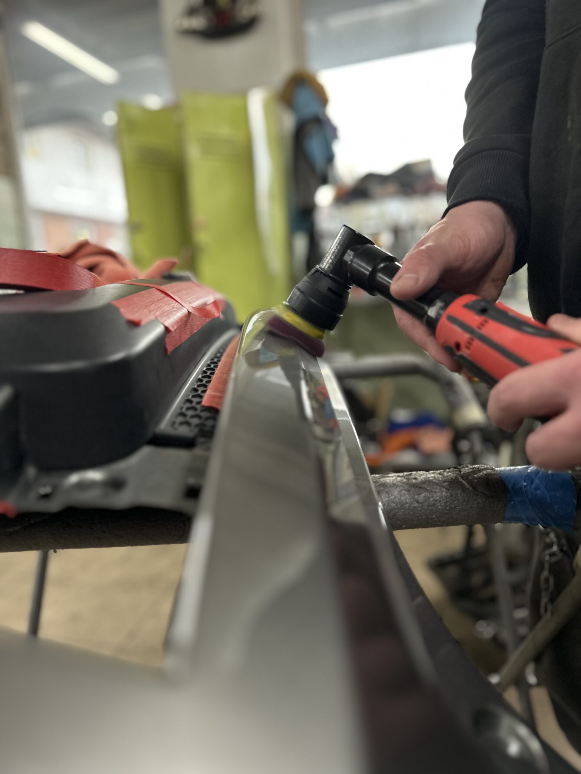 Lakiernik, blacharz lakieruje samochód w Białostockim zakładzie blacharsko-lakierniczym Motofirma.