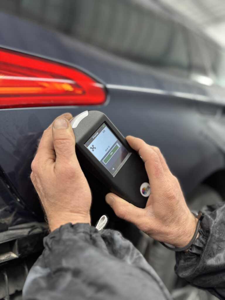 Lakiernik samochodowy lakieruje auto w zakładzie lakierniczym Motofirma w Białymstoku. Lakiernik Białystok.